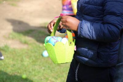 Un enfant portant un panier vert rempli d'œufs en chocolat. - Agrandir l'image 26 sur 55, fenêtre modale
