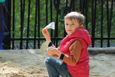 Un jeune garçon dans un bac à sable, fier d'avoir trouvé l'indice. - Agrandir l'image 7 sur 55, fenêtre modale